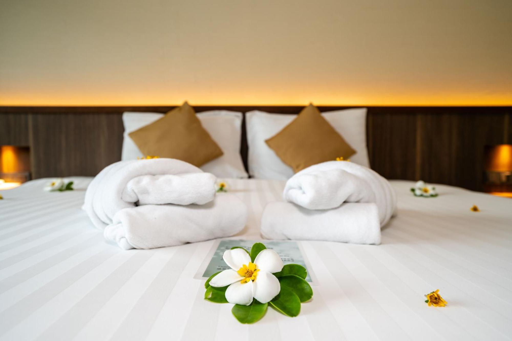 Le Resort And Villas Rawai Buitenkant foto A bed with towels and flowers